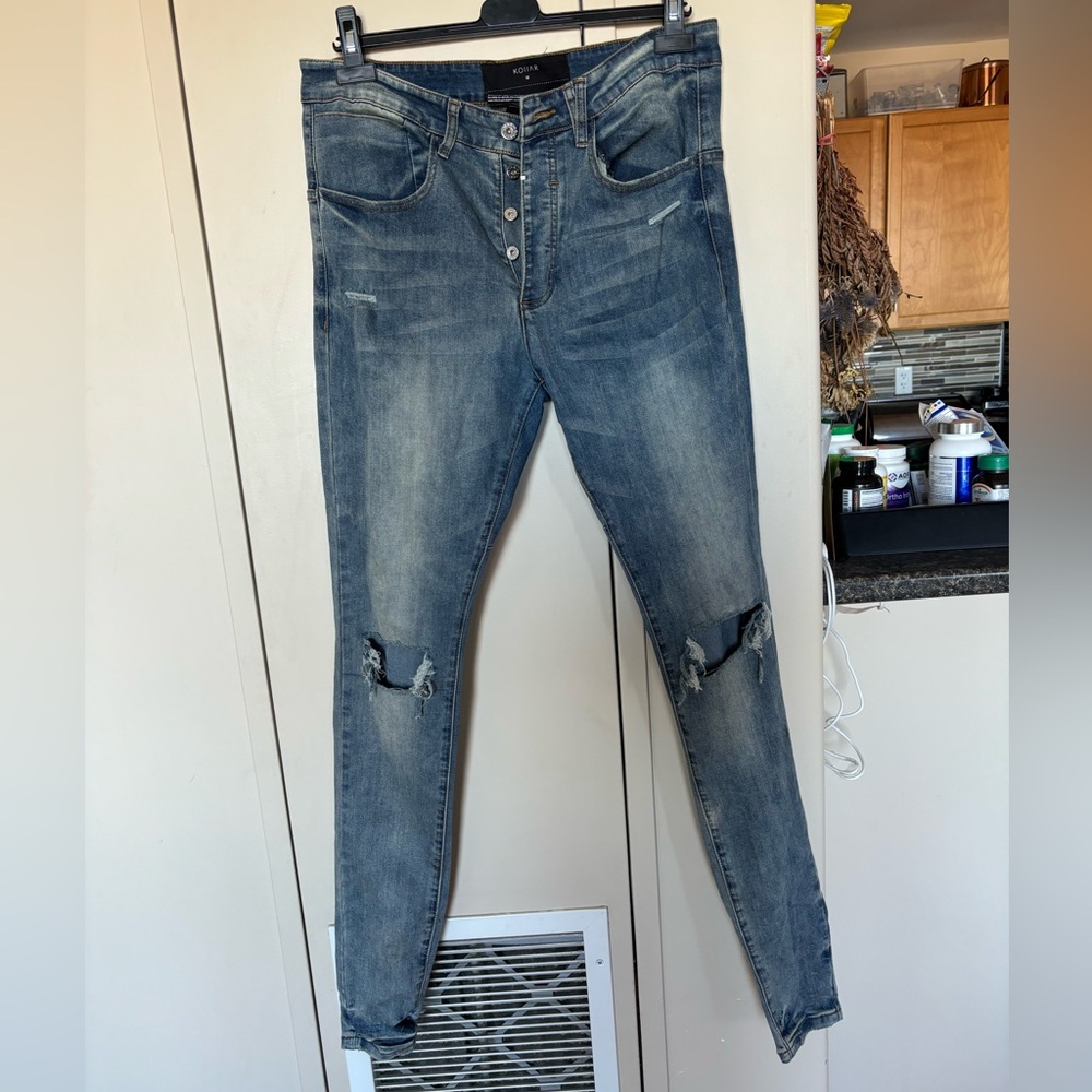 Kollar "knee-blown-out" jeans.